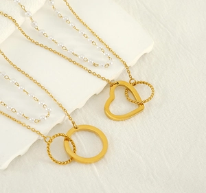 Close-up of double-layer stainless steel pearl necklace with heart and ring pendants