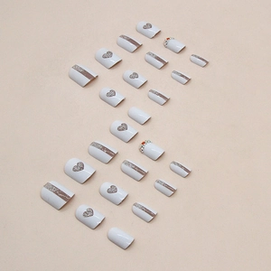 Faux ongles blancs avec cœurs pailletés argentés, rayures et petits strass brillants