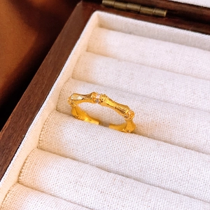 Vue détaillée d'une bague en bambou plaquée or 24 carats sertie de cristaux blancs brillants