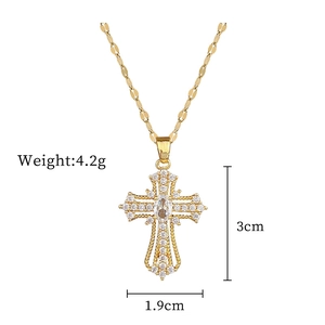Detailed view of gold cross pendant with cubic zirconia inlay measuring 3cm by 1.9cm