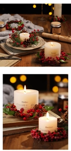 Macro shot of white pillar candle with red berry and pinecone wreath Christmas decoration