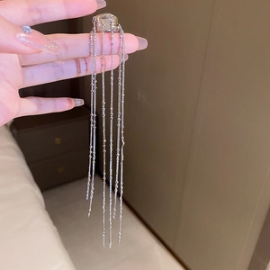 Detailed view of silver chain fringe earrings featuring irregular C-shaped metal design