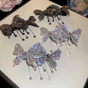 Elegant rhinestone butterfly tassel hair clips in silver and black on a floral background