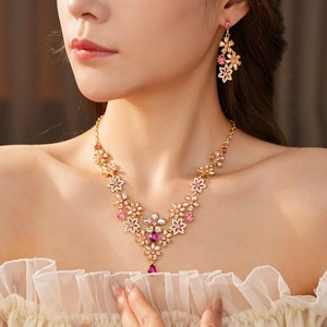Close-up of vintage floral jewelry set with pink and purple crystals on a female model
