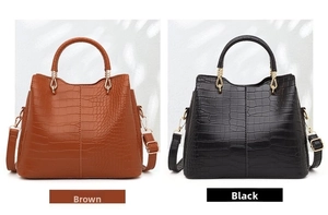 Detail view of brown and black tote bags with crocodile pattern and golden handles