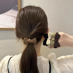 Close-up of bow knot fabric hair scrunchies showing soft ribbed texture and earth tones