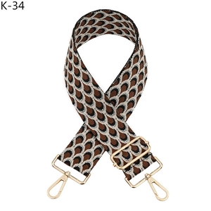 Détail de la bandoulière réglable tissée avec motif jacquard et mousquetons dorés brillants