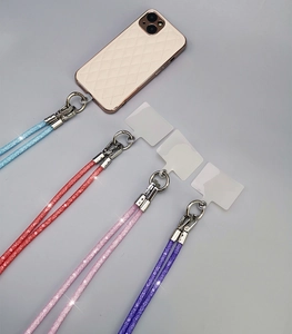 Detail of four colorful rhinestone glitter phone lanyards in blue, red, pink, and purple