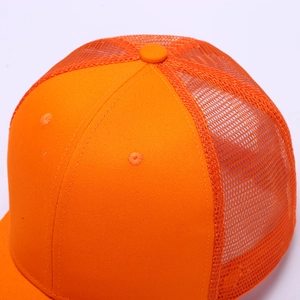 Close-up of bright orange trucker hat showing breathable mesh and fine top stitching