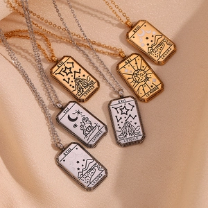 Detailed close-up of tarot card pendant necklaces in gold and silver on beige silk