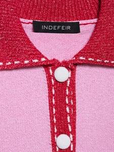 Close-up of pink knit polo collar with red stitching detail and white fabric buttons