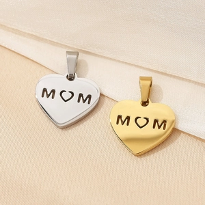 Detailed view of silver and gold heart pendants with MOM hollow engraving on silk fabric