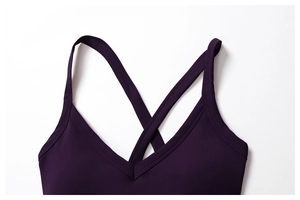 Detail of dark purple sports bra featuring a deep V-neck and thin criss-cross straps