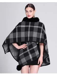 Detail view of jacquard cape with faux rabbit fur collar and playful black pom-poms