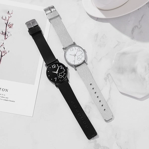 Detailed view of fashionable quartz watches with heart patterns on marble background