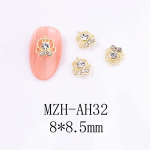 Vue macro des bijoux d'ongles couronne dorée 8x8,5 mm avec strass sur un ongle rose