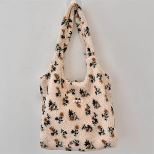 Detail of plush floral tote bag showing soft sherpa texture and colorful woven label