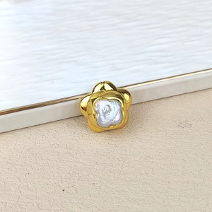 Macro view of gold plated flower pendant with baroque pearl center for DIY jewelry
