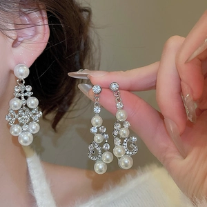Gros plan de boucles d'oreilles fleur en strass et perles sur un modèle