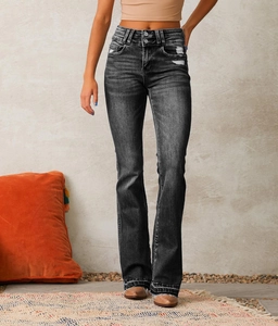 Detail of high waist distressed black flare jeans with washed finish and knee rips