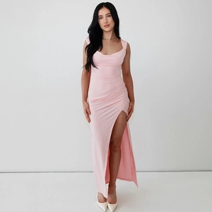 Détail de la robe rose clair ajustée montrant les plis à la taille et la fente haute