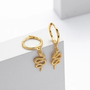 Detailed view of the golden snake pendant on a polished silver hoop earring set