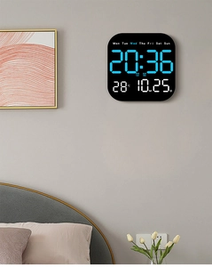 Blue LED digital clock mounted on bedroom wall displaying time temperature and date