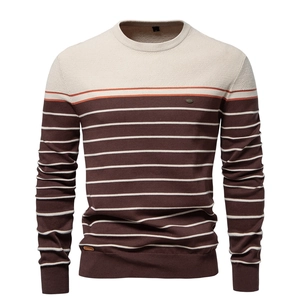 Detail of striped knit sweater showing brown, white and orange textured fabric