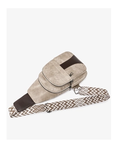 Detail of beige crossbody bag featuring textured fabric and wide geometric pattern strap