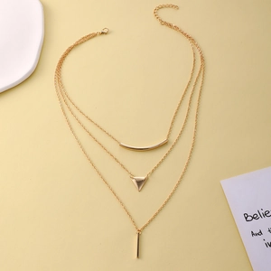 Collier géométrique à trois rangs doré avec pendentifs triangle sur fond jaune élégant