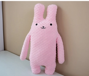 Detailed close-up of pink bunny plush toy featuring soft 3D dotted fabric and simple face