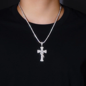 Close-up of a large iced-out silver cross pendant with a matching tennis chain