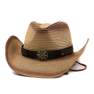 Detail of straw cowboy hat featuring metal flower buckle and black rivet leather band