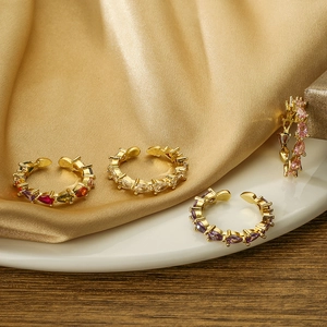 Elegant gold plated adjustable ring with colorful pear cut zircons on silk background