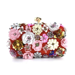 Detail of red satin evening clutch with 3D floral sequins and gold crystal clasp