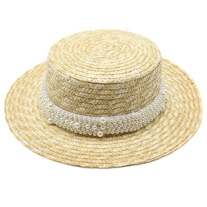 Vue détaillée d'un chapeau de paille avec bande de perles décorative élégante