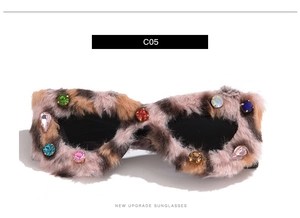 Macro view of fur-trimmed cat eye sunglasses with multi-colored rhinestones and jewels