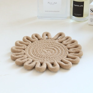 Close-up of a woven flower-shaped jute placemat with a natural spiral cotton rope texture