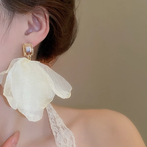 Detailed close-up of champagne zircon and layered mesh petal earrings on a model