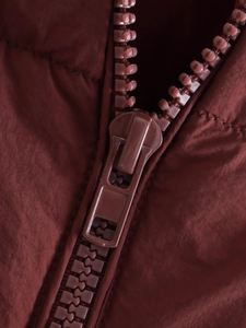 Detailed close-up of dark reddish-brown nylon fabric with matching high-quality zipper