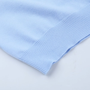 Gros plan du pull en tricot bleu clair montrant la texture côtelée et le tissu doux