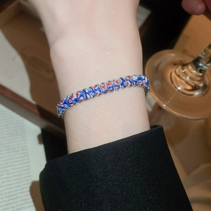 Détail du bracelet chaîne à la mode avec émail marbré bleu et motifs de cœurs rouges