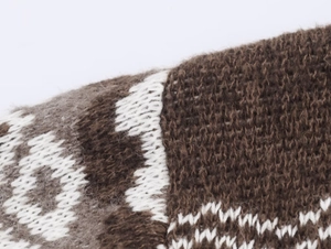 Macro shot of jacquard knit texture with earth tone geometric patterns and wool fibers