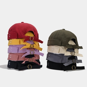 Dettaglio di cappelli Miki colorati con ricamo C e fibbie in metallo regolabili sul retro