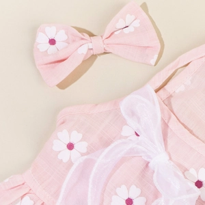 Close-up of pink floral dog dress fabric with white daisy prints and mesh bow detail