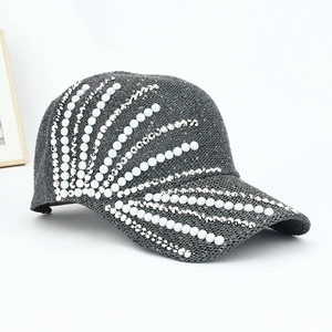 Detailed close-up of a grey mesh baseball cap with pearl and silver stud embellishments
