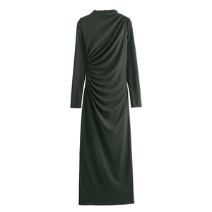 Detail of elegant side ruching and draped fabric on a dark green long sleeve midi dress
