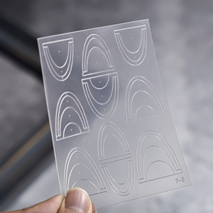 Detailed view of clear F-5 stencil for nail art with rainbow geometric patterns