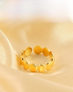 Detail of 18k gold plated stainless steel shell ring on champagne silk background