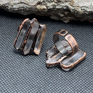 Front and back view of a vintage bronze ring featuring three natural white crystal pillars